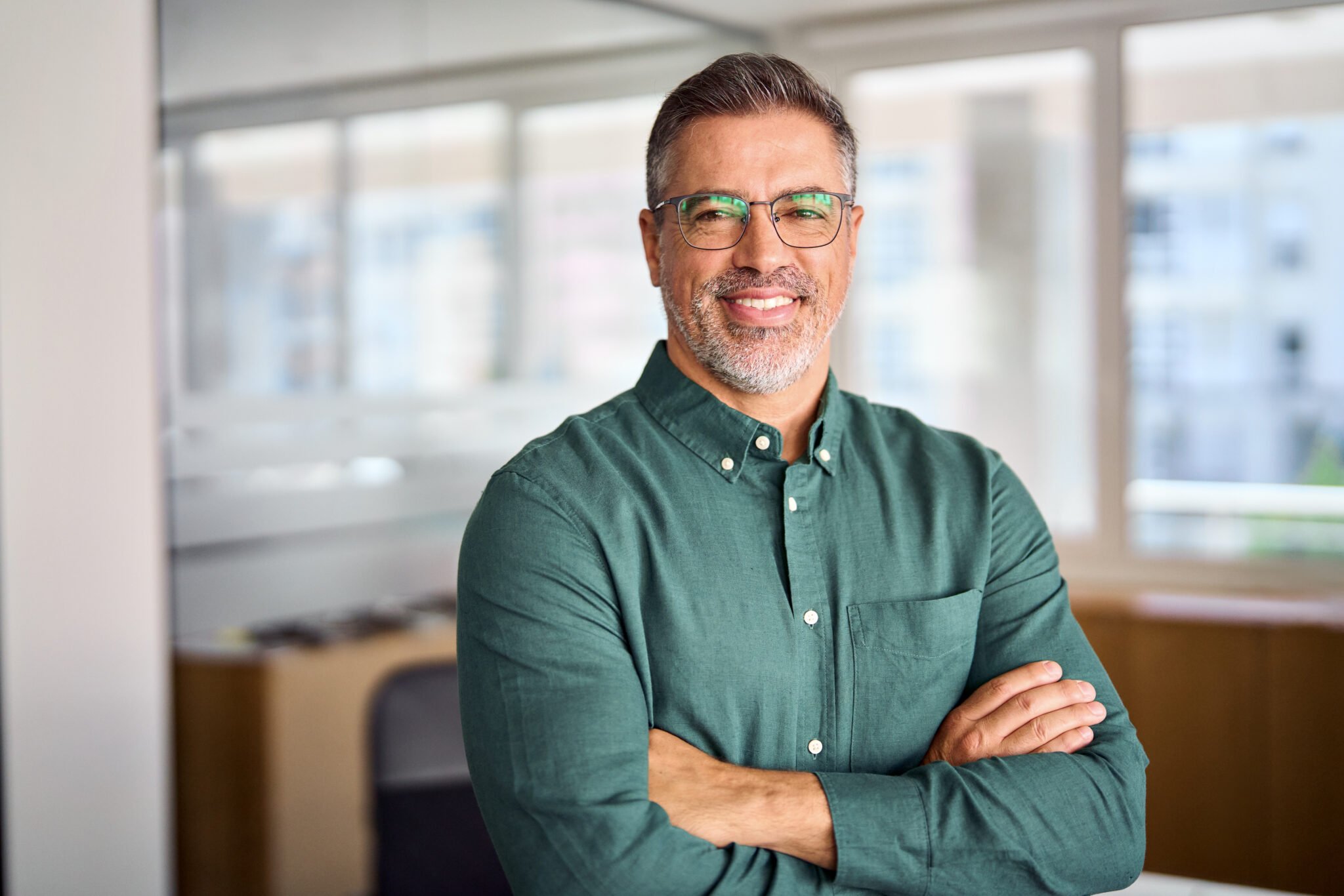 Smiling older middle aged business man standing in office, headshot portrait